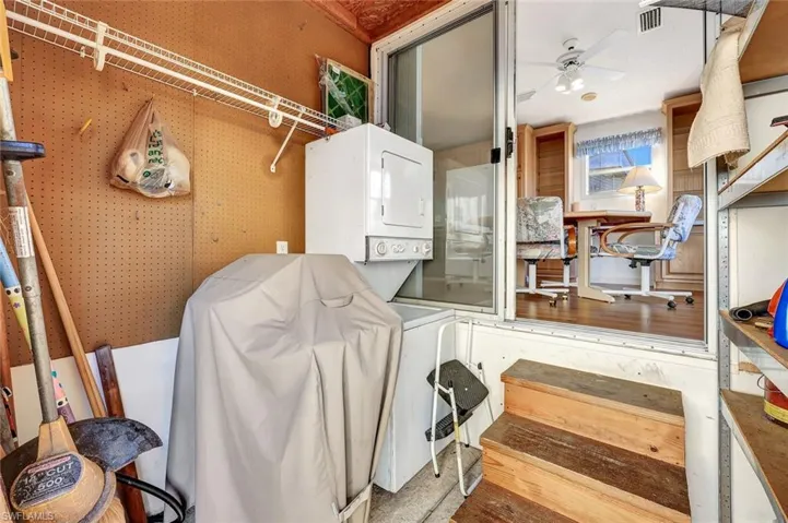 Laundry room with stacked washer and clothes dryer and a ceiling fan
