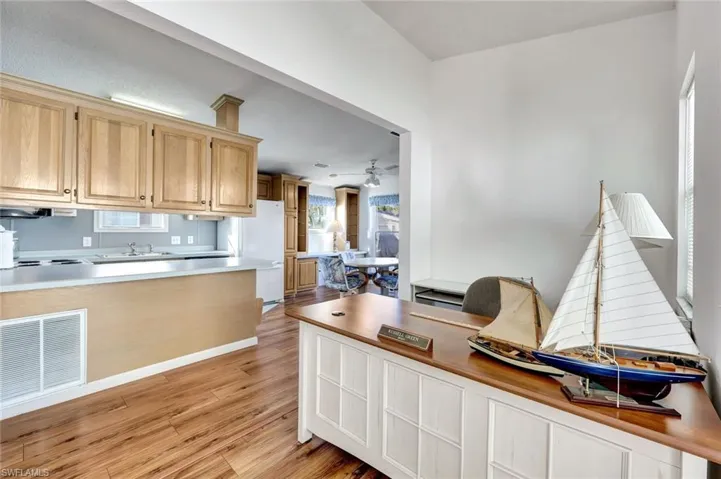 Kitchen with light wood-type flooring, ceiling fan, and light brown cabinets
