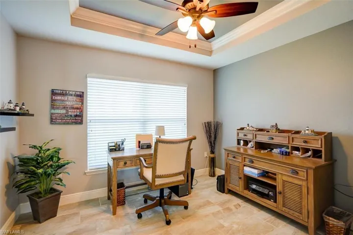 Office featuring a raised ceiling, ornamental molding, and plenty of natural light