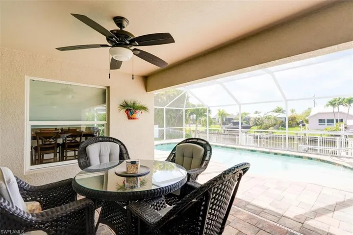 View of patio / terrace featuring a fenced in pool, glass enclosure, and ceiling fan
