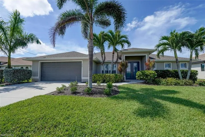 Ranch-style house featuring a garage and a front yard