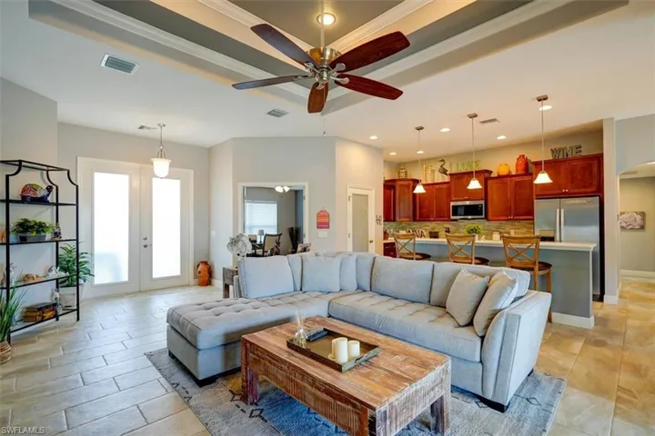 Living room with french doors, ceiling fan, and crown molding