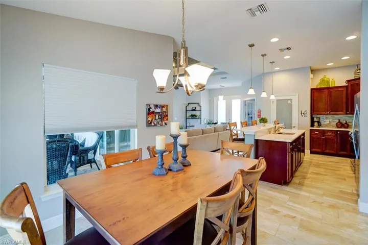 Dining area featuring light wood-type flooring, sink, and a notable chandelier