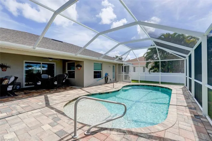 View of swimming pool featuring glass enclosure, a patio, and ceiling fan