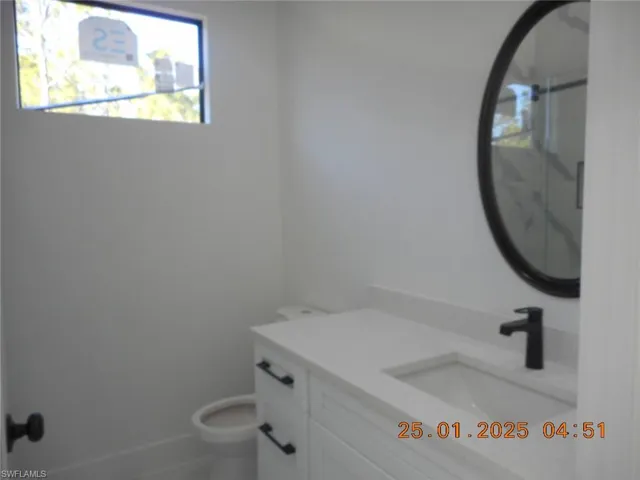 Guess Bathroom featuring vanity and toilet