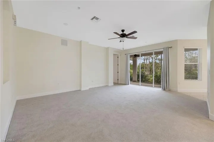Carpeted spare room featuring ceiling fan