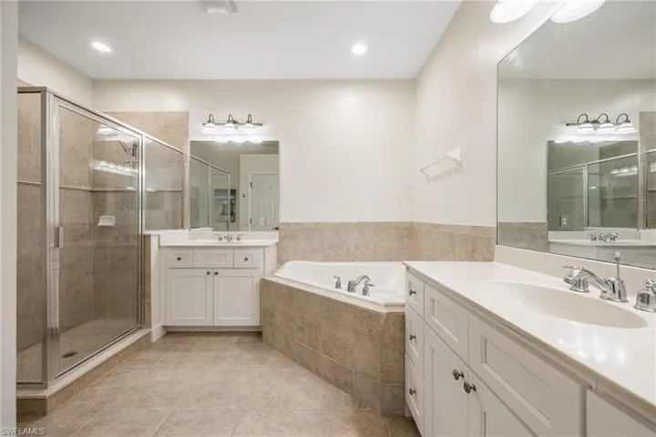 Bathroom featuring vanity, tile patterned floors, and separate shower and tub