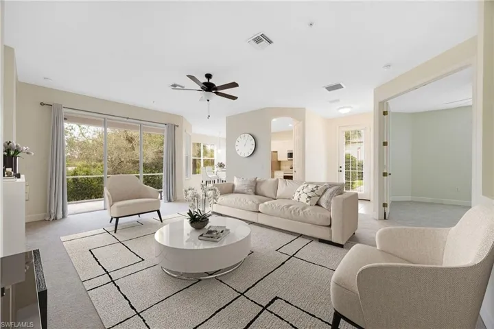 Living area with light colored carpet and a ceiling fan