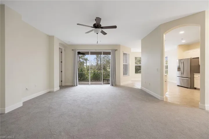 Unfurnished living room featuring light colored carpet and ceiling fan