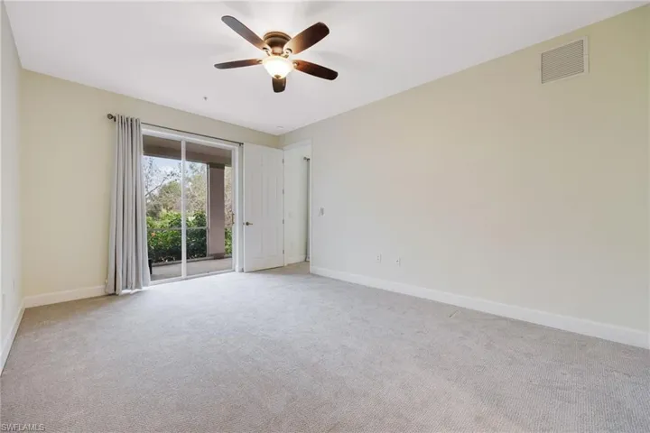 Empty room with light colored carpet and ceiling fan