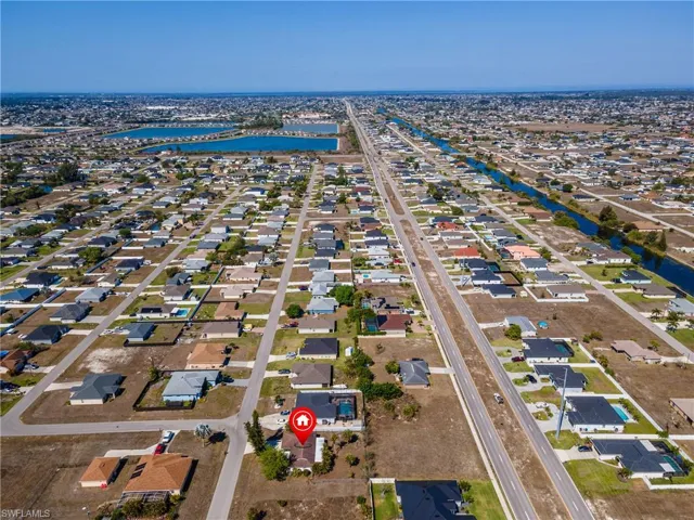 Aerial view of property and surrounding area with nearby suburban area and a large body of water