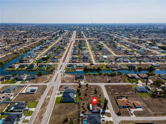 Aerial view of property and surrounding area featuring nearby suburban area and a large body of water