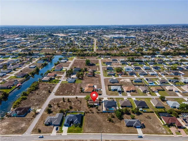 Aerial view of property and surrounding area with nearby suburban area and a large body of water