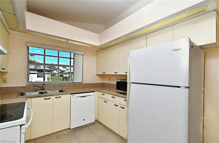 Kitchen with white appliances and light tile patterned floors