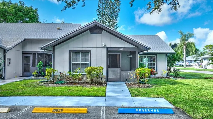 Single story home with roof with shingles, a front lawn, and uncovered parking