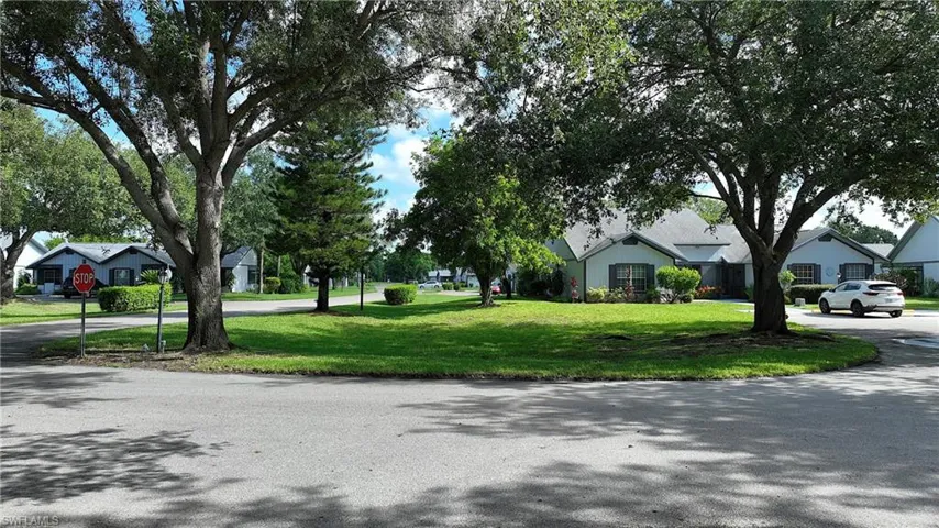 View of asphalt street featuring traffic signs and a residential view