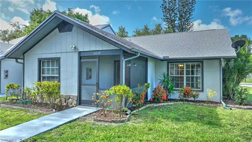 Ranch-style home with a shingled roof and a front yard