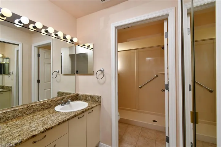 Bathroom with vanity, a stall shower, and tile patterned floors