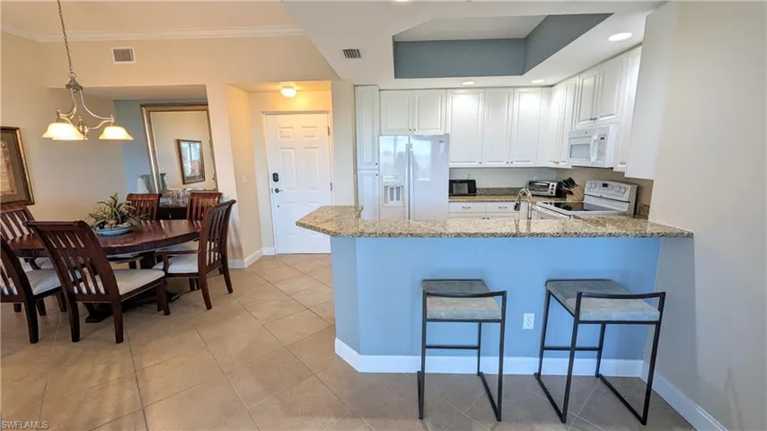 Kitchen with white appliances and white cabinetry,