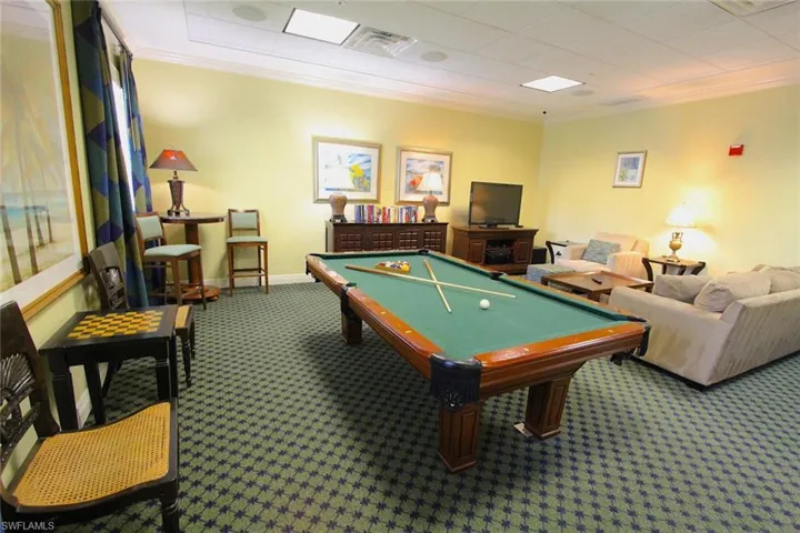 Billiards room in clubhouse with carpet floors, ornamental molding, and pool table