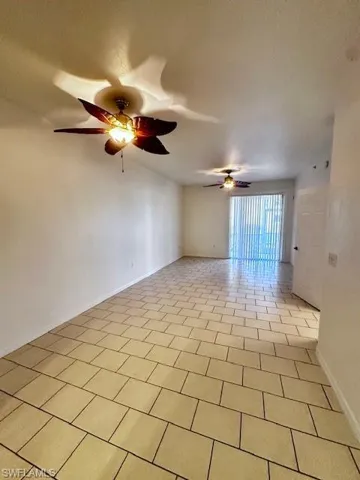 Spare room with a textured ceiling, ceiling fan, and light tile patterned floors
