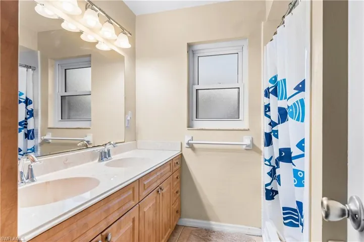Bathroom featuring double vanity and curtained shower