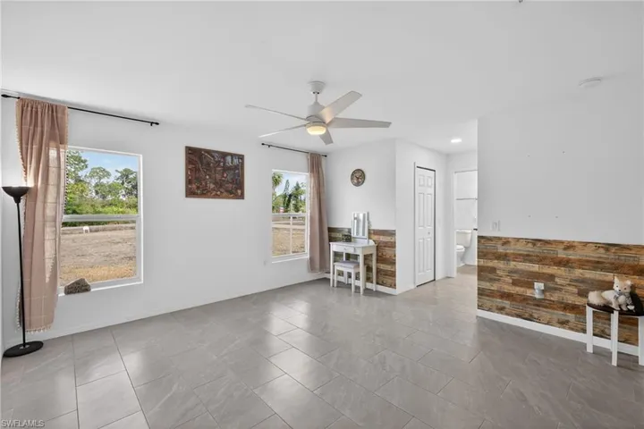 Primary Bedroom featuring ceiling fan and baseboards