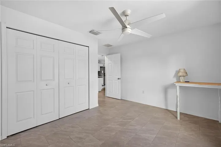 Unfurnished bedroom with a ceiling fan and a closet