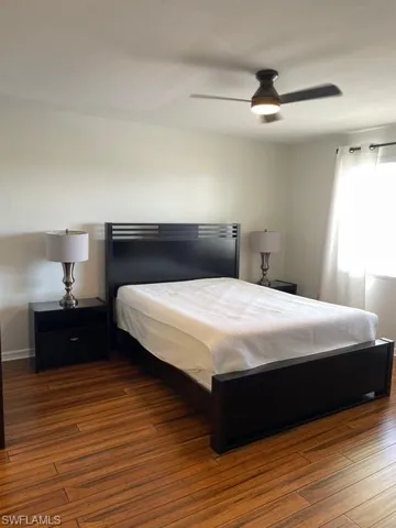 Bedroom featuring a ceiling fan and dark wood-type flooring