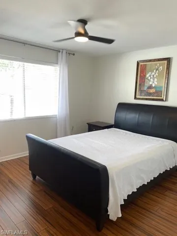Bedroom with dark wood-type flooring and a ceiling fan