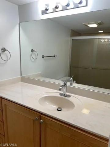 Full bathroom with vanity and a shower stall