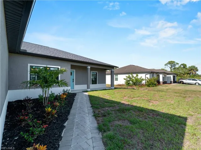 View of front of home with stucco siding and a front lawn