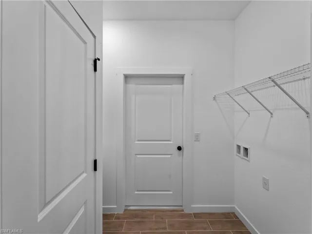 Washroom with hookup for a washing machine, baseboards, and wood tiled floors