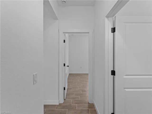 Corridor with wood finish floors and baseboards