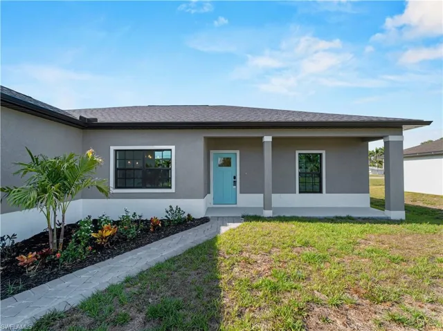 View of front of property with a front lawn, stucco siding, and a porch