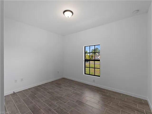 Empty room featuring baseboards