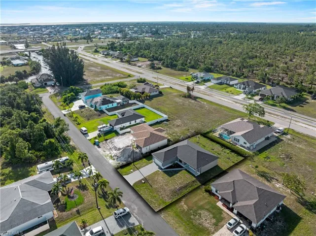 Aerial view of property and surrounding area with nearby suburban area