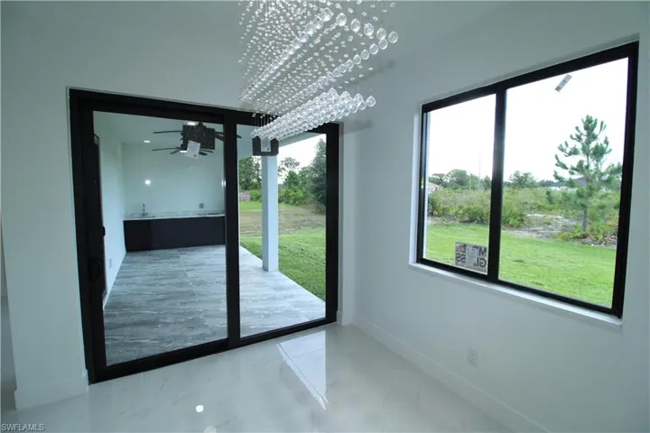 Doorway with a notable chandelier and tile flooring