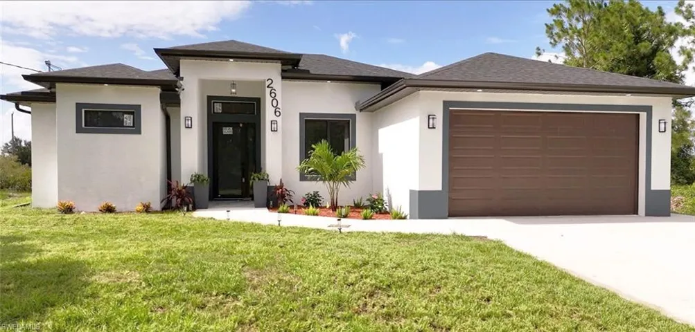 Prairie-style house featuring a garage and a front lawn