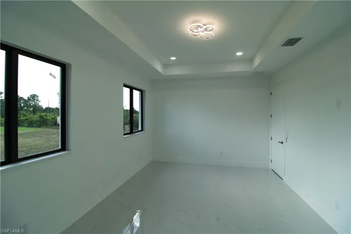 Empty room with a tray ceiling and tile floors
