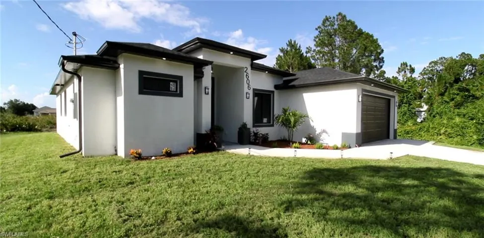 View of front facade featuring a front lawn and a garage