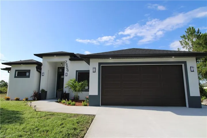 View of front facade with a garage and a front lawn