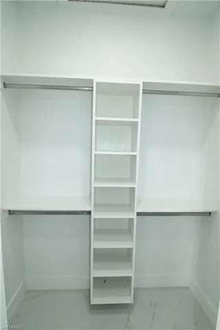 Walk in closet with tile flooring