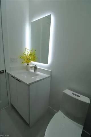 Bathroom featuring vanity with extensive cabinet space, tile flooring, and toilet