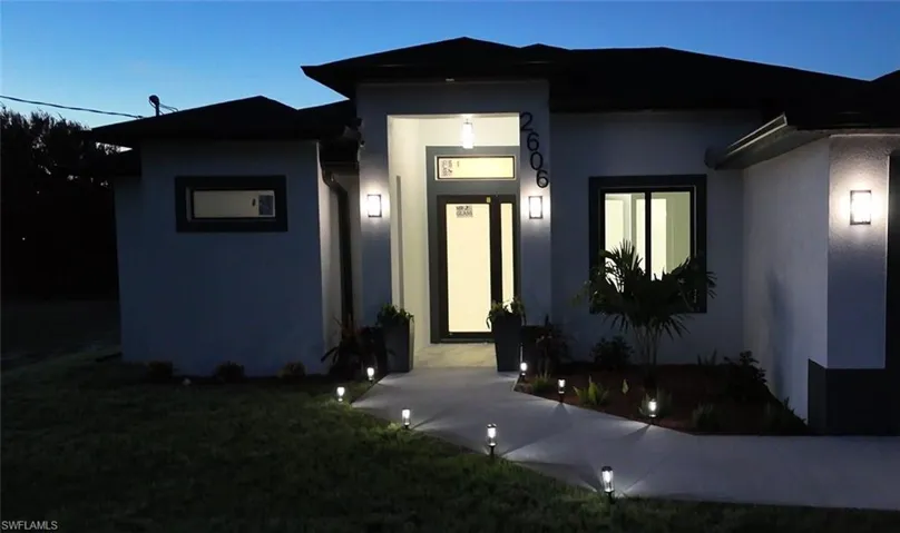 Exterior entry at night with a yard