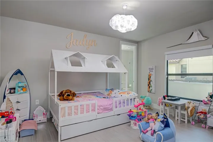 Bedroom with light wood-style floors and a chandelier