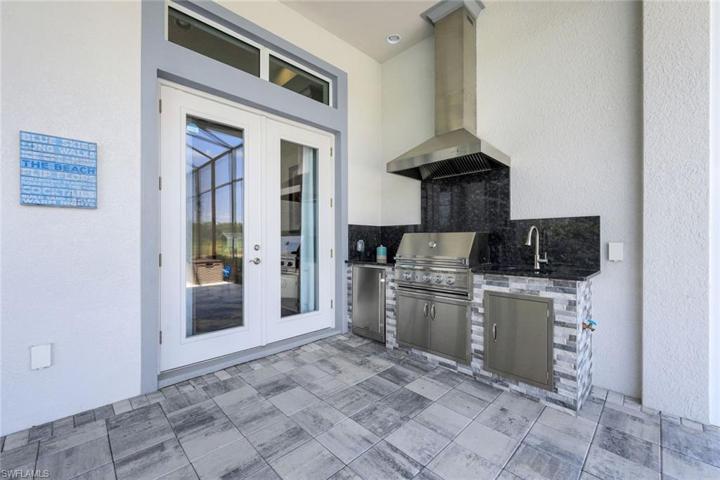 Outdoor kitchen with refrigerator, sink and natural gas.