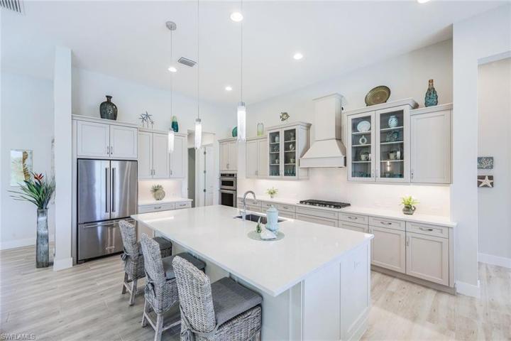 White modern cabinetry, quartz countertops, decorative hood, stainless appliances and more!