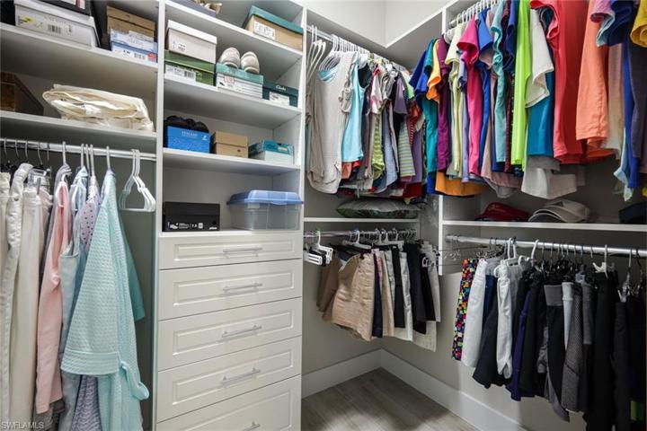 His & Hers master closet with custom organizer/shelving system.
