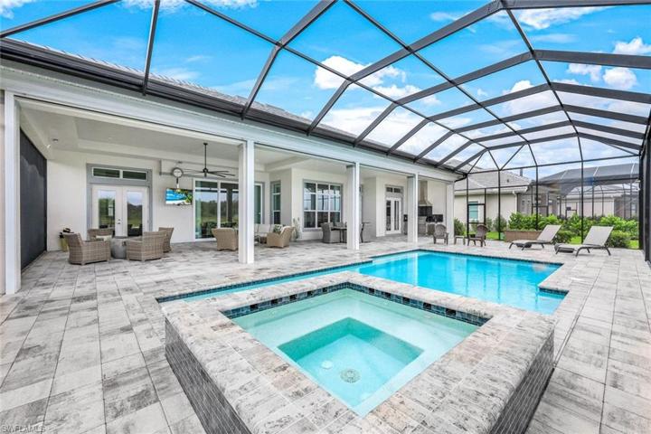 Relax poolside with your favorite beverage while watching the game on the outdoor television.